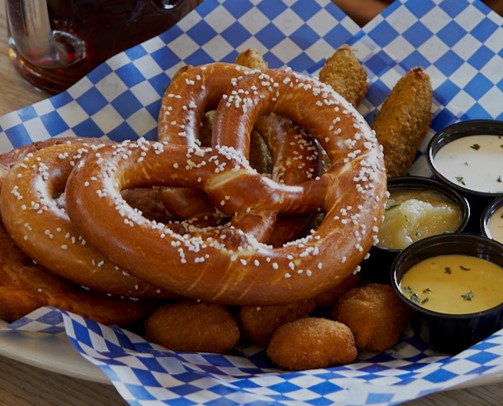 Hofbrauhaus Columbus signature dishes  Giant Pretzel with beer cheese, Schweinshaxe (pork knuckle), various sausages (Bratwurst, Mettwurst), Wiener Schnitzel, Hofbräu beer.